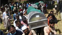 बीजेपी के पूर्व ज़िला अध्यक्ष वसीम बारी का शव ले जाते लोग