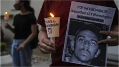An activist holds a placard outside the Singaporean embassy in Kuala Lumpur, Malaysia, on 8 November 2021