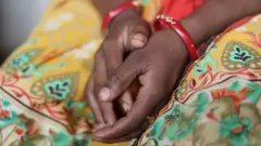 Рки женщины, сложенные на коленях.