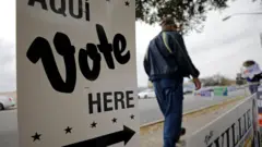From March: Person walks by polling site in San Antonio, Texas