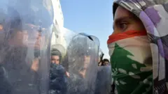 متظاهر يواجه أفراد الأمن