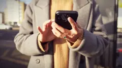A woman using her phone in the street