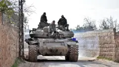 Suriye ordusuna bağlı askerler Sarakeb'in güneybatısında. Şam, M5 karayolunu kontrol altına almak istiyor.