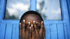 a kid hides her face