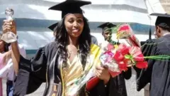 ኦብሲቱ ዱባ በምረቃ ጋወን የተሸለመችውን ዋንጫ ይዛ