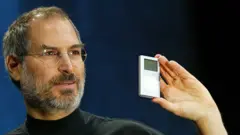 Apple CEO Steve Jobs holds a new mini iPod at Macworld January 6, 2004 in San Francisco.