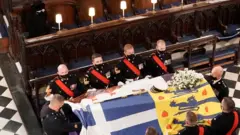 Queen Elizabeth II watches as the coffin of the Duke of Edinburgh is placed St George"s Chapel, Windsor Castle, Berkshire during his funeral service.