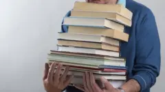 رجل يحمل كتبا
