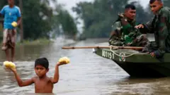 সেনাবাহিনীর দেয়া খাদ্য ত্রাণ নিয়ে ফিরছে এক কিশোর।