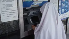 Woman wearing Hijab at a Bank ATM