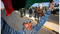 ليبي يحمل علم بلده