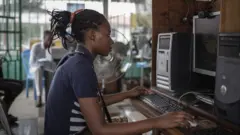 Une fille en République démocratique du Congo sur un ordinateur.