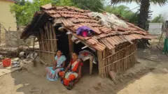 Women of Kanal Tola outside their period hut