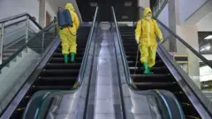 Employees spray disinfectant as part of preventative measures against the Covid-19 coronavirus at the Pyongyang Children's Department Store in Pyongyang on March 18, 2022.