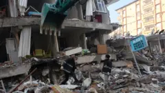 Des sauveteurs travaillent sur le site d'un bâtiment effondré, à la suite d'un tremblement de terre meurtrier à Hatay, en Turquie, le 8 février 2023.
