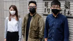 周庭（左）、黃之鋒（右）、林朗彥（中）在香港西九龍法院大樓外（23/11/2020）