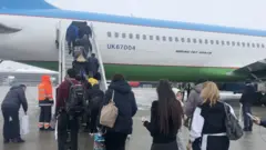 Россияга учадиган самолётга чиқаётган ўзбекистонликлар