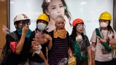 Người biểu tình Hong Kong hô to khẩu hiệu tại trạm xe điện ngần Sheung Wan trong khi đụng độ đang diễn ra