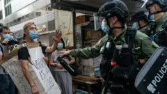 A man wearing a Voting Is A Right costome stand off with riot police during an anti-government protest on September 6, 2020 in Hong Kong