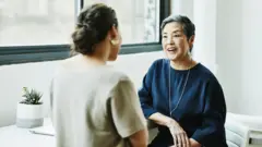 Dos mujeres hablando en un despacho