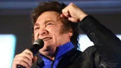 Argentine presidential candidate Javier Milei raises a fist during the closing event of his electoral campaign ahead of the November 19 runoff election, in Cordoba, Argentina, November 16, 2023