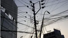 বিদ্যুতের খুঁটির ওপর এবড়ো খেবড়ো তার।