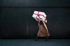 Mujer lleva caja de regalos