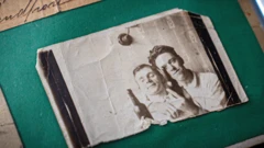 Fotografia antiga e desgastada, em preto e branco, de dois jovens posando com garrafas de cerveja. Gordon McPherson está à direita e um homem desconhecido, à esquerda.