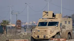 24 Ocak 2026'da Suriye'nin Haseke kentindeki IŞİD üyelerinin tutulduğu bir hapishaneye ABD'ye ait bir Chinook helikopteri iniş yapıyor. Odakta zırhlı silahlı bir araç var. 