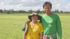 บุญฤทธิ์ หอมจันทร์ (ซ้าย) กับภรรยา บนผืนนาของเขาในจังหวัดชัยนาท
