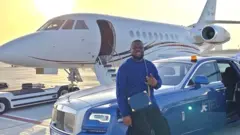 Nigerian influencer Ramon 'Hushpuppi' Abbas tanda for front of plane