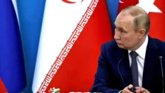 ولادیمیر پوتین که پشت سرش پرچم ایران است