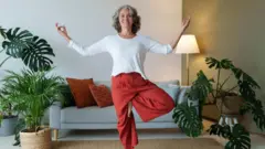 Una mujer se para en un pie.