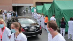 Hospital staff turn their backs