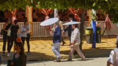 مردم در سِویل با چتر خود را خنک نگه می دارند