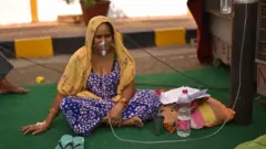 A suspected covid patient in India waits for oxygen at a Sikh shrine