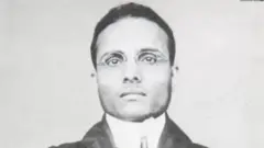 13 માર્ચ 1910ના રોજ વિક્ટોરિયા સ્ટેશન પર ધરપકડ બાદ લેવાયેલી સાવરકરની તસવીર