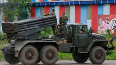 Cambodian military personnel stand on a rocket launcher in northern Oddar Meanchey province.