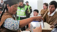 Una mujer deposita su voto en Bolivia