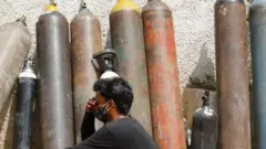 A man waits outside a factory to get his oxygen cylinder refilled, amidst the spread of the coronavirus disease (COVID-19) in New Delhi, India, April 28, 2021. REUTERS/Adnan Abidi