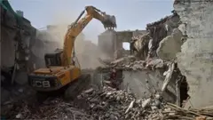 A bulldozer is being used to demolish the illegal structures of the residence of Javed Ahmed, a local leader who was allegedly involved in the recent violent protests against Bharatiya Janata Party (BJP) former spokeswoman Nupur Sharma's