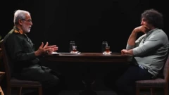 تصویری از گفتگو که در آن حسین نجات در حال صحبت است و جواد موگویی روبروی او نشسته و گوش می‌کند