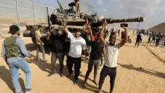 : The Al-Qassam Brigades, the armed wing of the Palestinian resistance group Hamas annihilate Israeli tank as smoke rises near Israel-Gaza border in Gaza Strip, Gaza on October 07, 2023