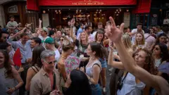 Гуляки танцюють на вулиці під час Fete De La Musique 2025, а гурти та діджеї грають на вулицях французької столиці.