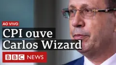 Close no rosto de Carlos Wizard e o texto: ao vivo - CPI da Covid ouve Carlos Wizard