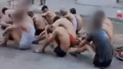 Palestinian men in their underwear, sat on the ground