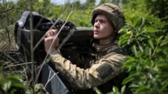 A Ukrainian service member holds a next generation light anti-tank weapon at a position on the front line, near Bakhmut, Donbas region