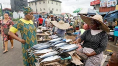 A customer speaks to a fish seller in Lagos, Nigeria - 2022
