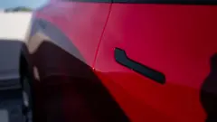 A black door handle on a red Tesla Model Y at a charging station in San Francisco, California, US.