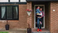 Man leaves his house with his child
